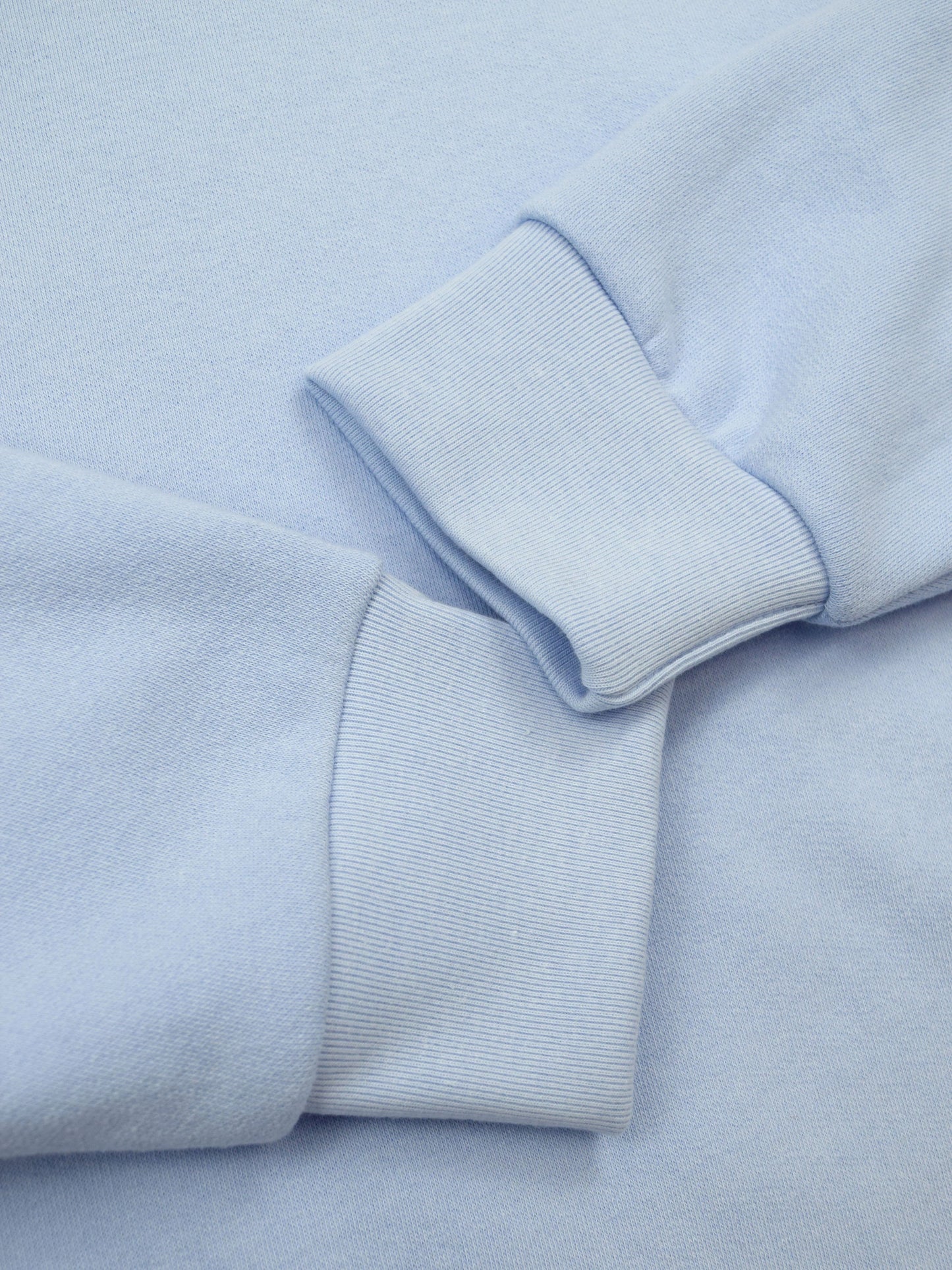 Ribbed cuffs of airy blue crewneck