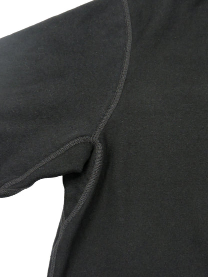 Close up of seams near shoulder and underarm of crewneck garment.