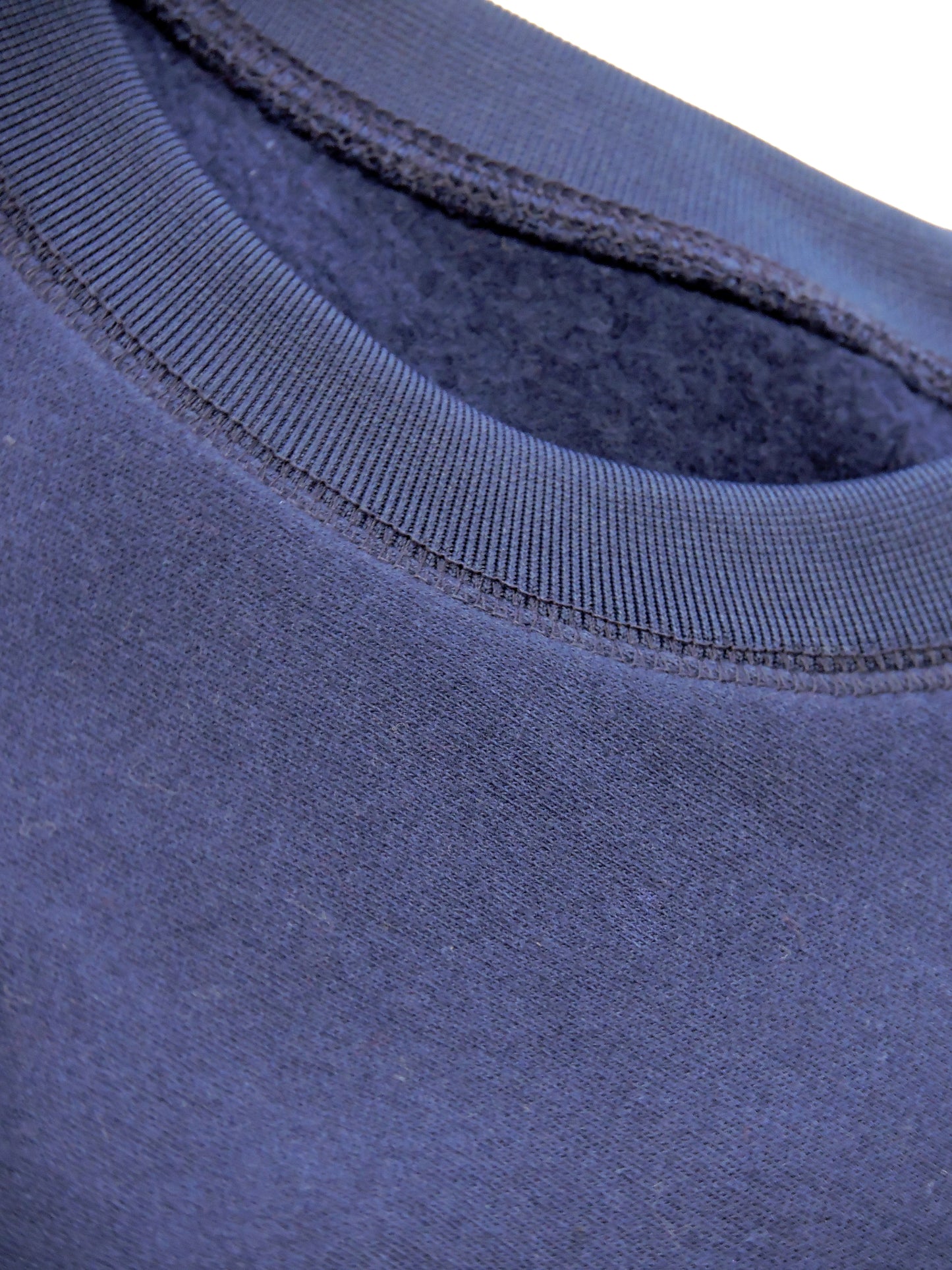 Close up of crewneck, knitting around the neckline and warm fleece interior