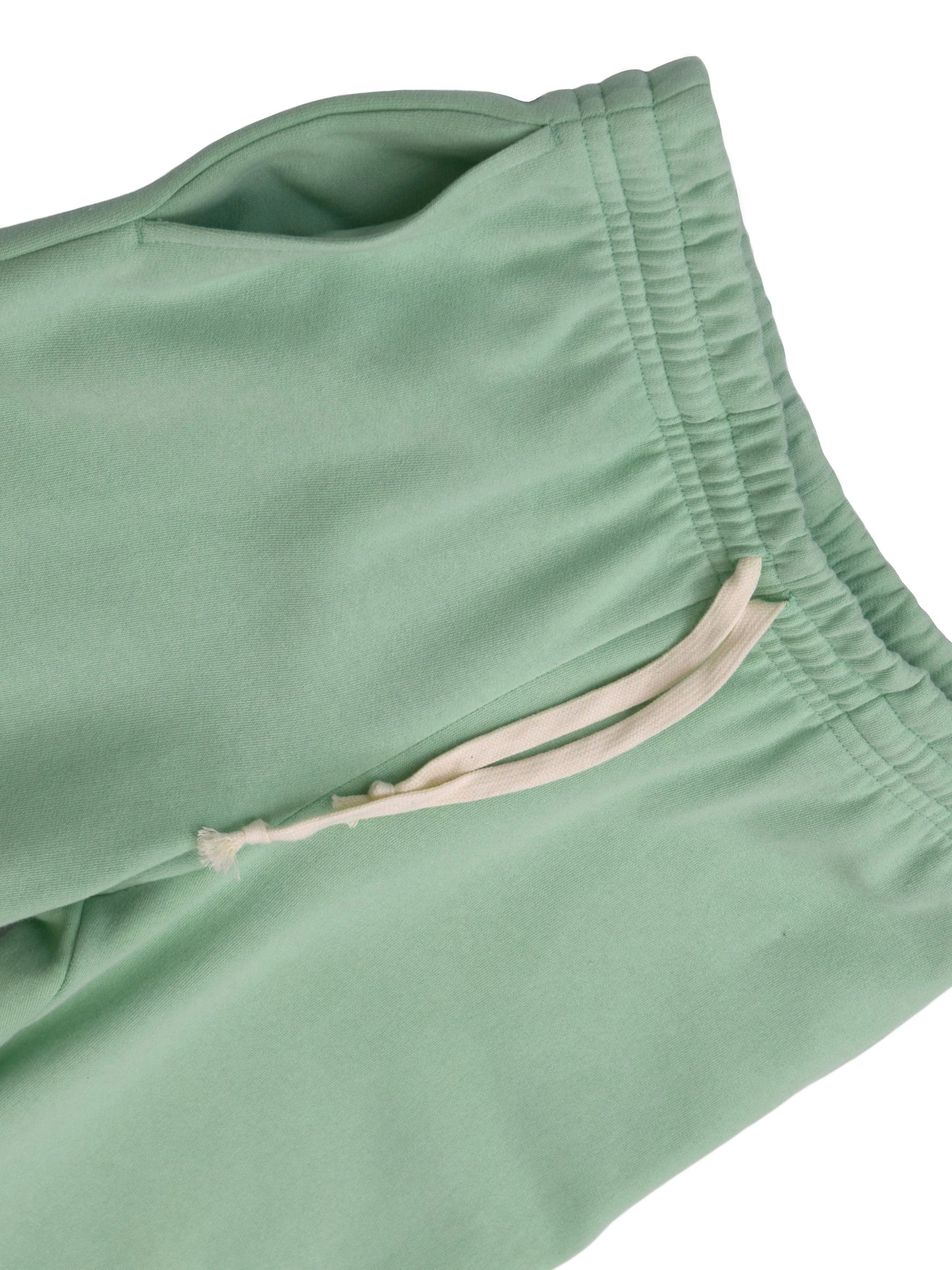 Angle showing soft texture of mint green cotton fabric.
