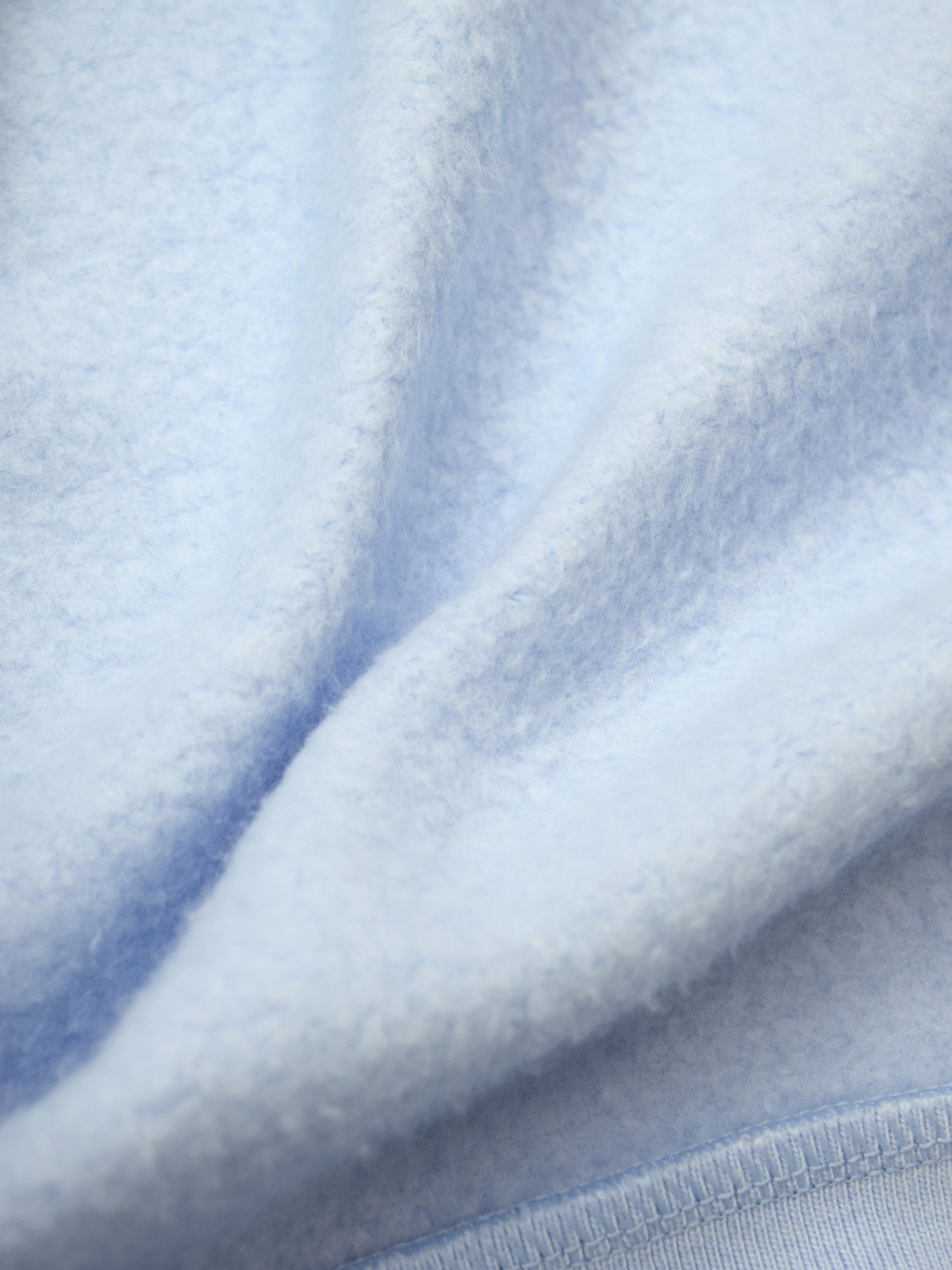 Close up of airy blue fleece material used to craft longshort.