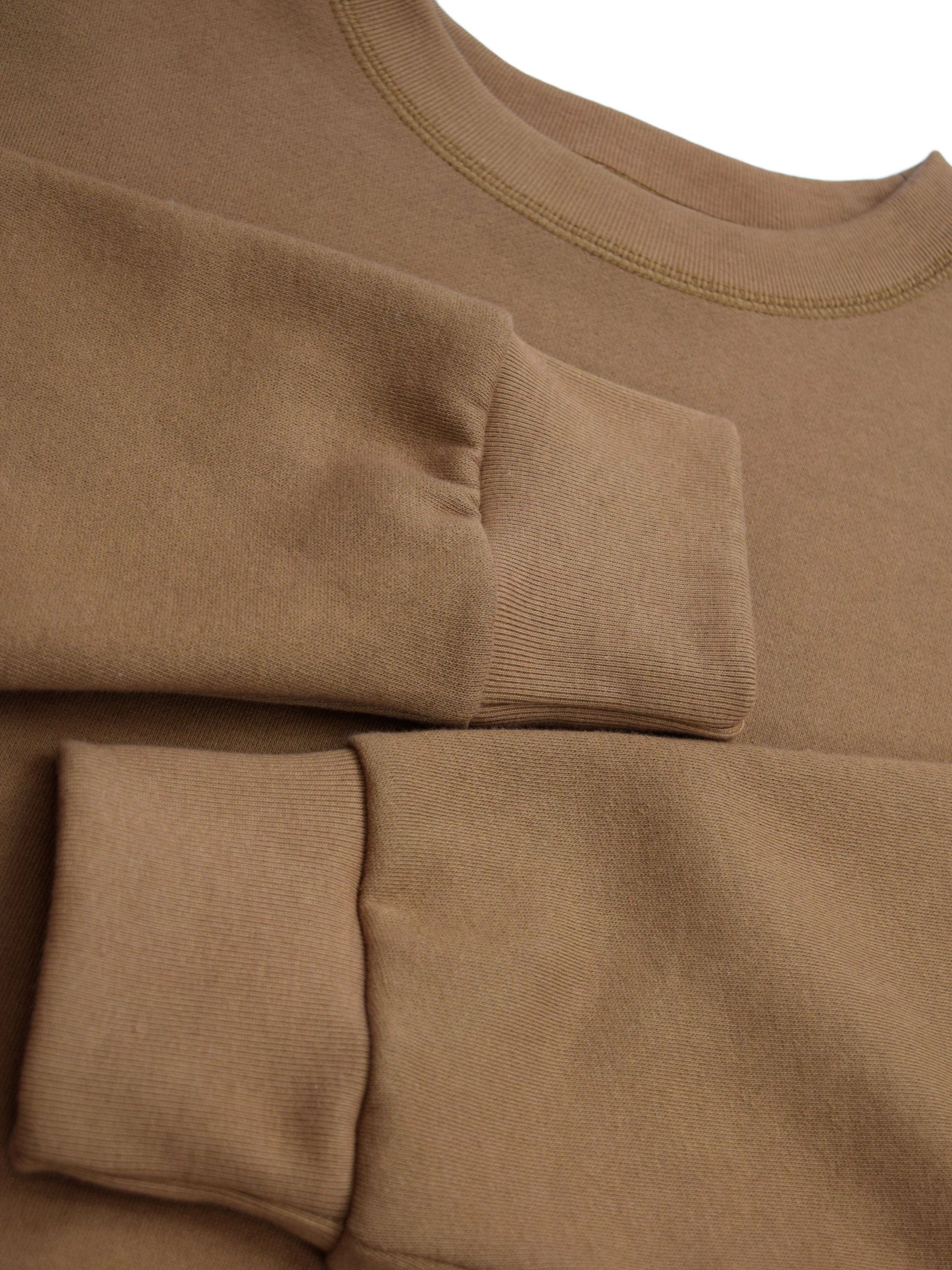 Sleeves folded over middle of sweater, close-up of fitted cuffs